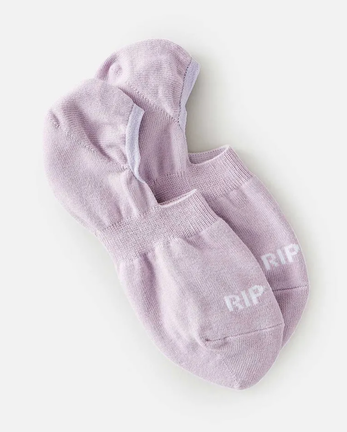A pair of light purple Rip Curl Womens Invisible Socks with a ribbed design is displayed on a white surface. They feature the Rip Curl logo in white on the toes and an inner heel silicon grip for a snug fit.