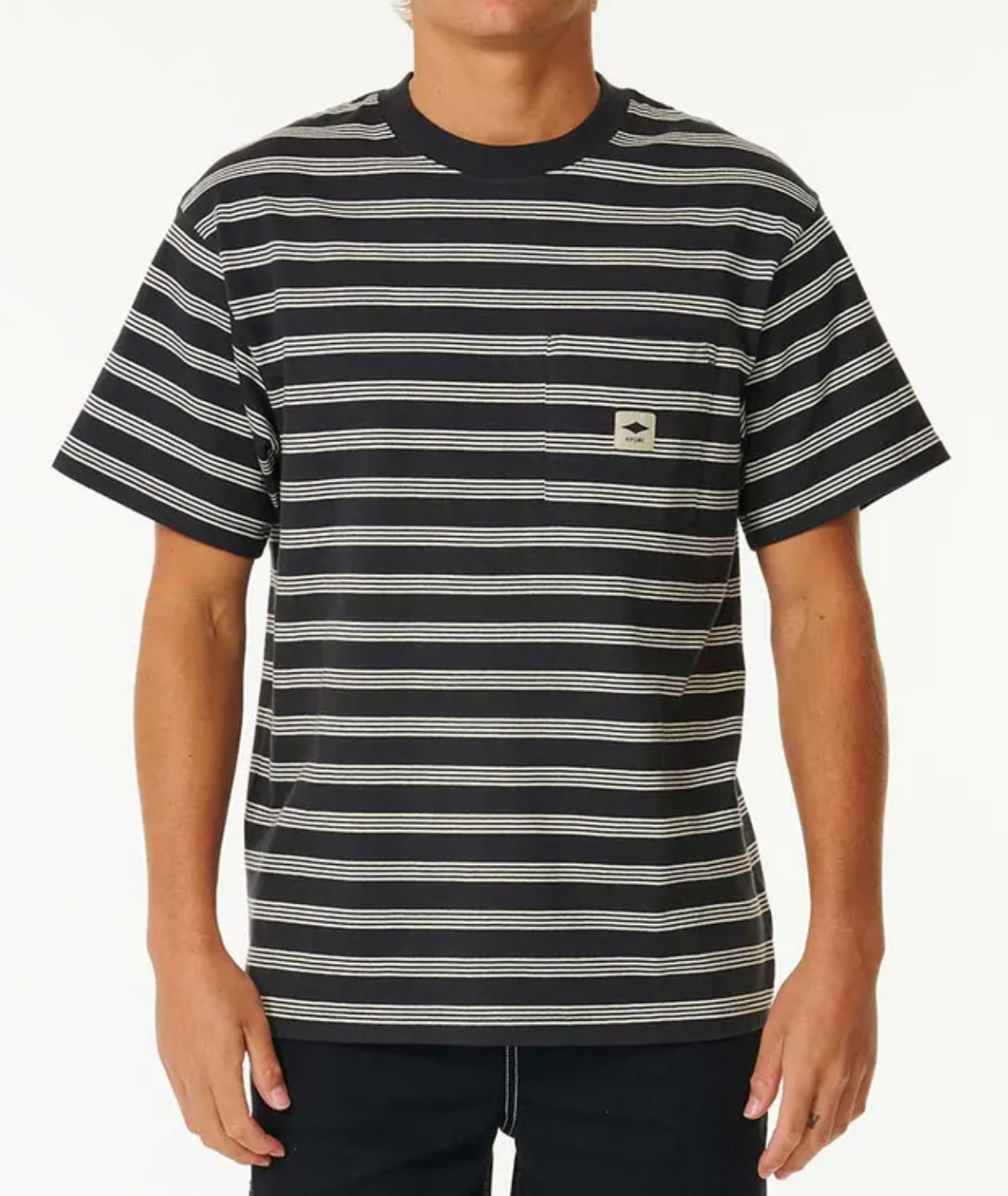 A person wears a short-sleeved, black Rip Curl Quality Surf Products Stripe Tee with white horizontal stripes and a small chest pocket against a plain background.