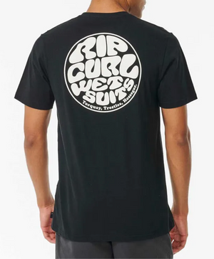 Man wearing the Rip Curl Wetsuit Icon Tee—black with a bold white circular "Rip Curl Wetsuits, Torquay, Trestles, Hossegor" graphic on the back. Made from 100% cotton for all-day comfort and casual style.