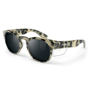 SafeStyle Cruisers sunglasses with a Milky Tort frame in beige, black, and green camouflage, round dark polarised lenses, UV protection, side shields, and a white signature logo on the left temple.