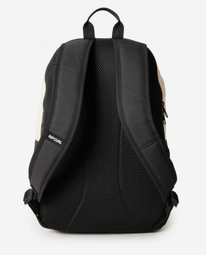 The Rip Curl Ozone 2.0 30L Backpack in black is made from recycled polyester and features padded, mesh-lined shoulder straps. It includes a discreet "RIP CURL" label on one strap, buckle adjustments at the bottom, and a convenient laptop section for essentials.