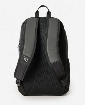 The Rip Curl Ozone Icons 30L Backpack in black and gray is shown from the back, featuring padded shoulder straps, a top handle, and a mesh-padded back panel for ventilation. A curved logo is visible on the left strap, and the interior includes organizer pockets for easy storage.
