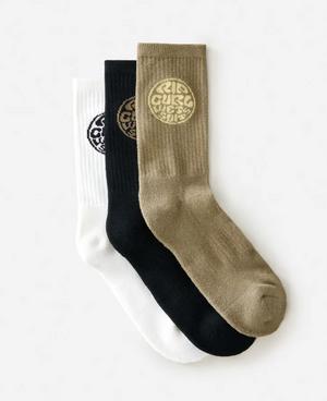 The Rip Curl Wetty Crew Sock 3 Pack includes three overlapping crew socks—white, black, and olive green—each with a circular logo near the cuff and made from a soft acrylic blend for lasting comfort.