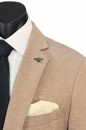 Close-up of a beige Scuzzatti Stretch Slim Fit Sports Jacket with a single-button notch lapel, white shirt, black tie, cream pocket square, and bee lapel pin. Made from lightweight stretch fabric. Plain white background.