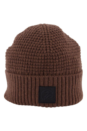 The Swanndri Newton Beanie is a brown waffle knit beanie with a thick, textured pattern, ribbed folded brim, and a black rectangular patch on the front.