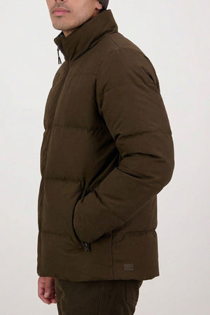 A person models the Swanndri Nimbus Down Jacket, standing sideways with hands in the pockets against a plain light background, showing only the lower half of their face.