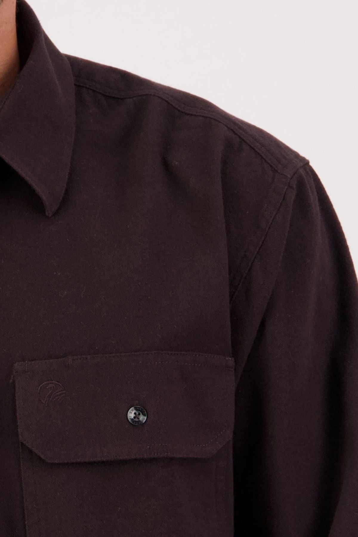 Close-up of a person wearing a Swanndri Barn Shirt, featuring 100% cotton fabric, a collar, and chest pocket—perfect for winter layering. Only the left side and part of the shoulder are visible.