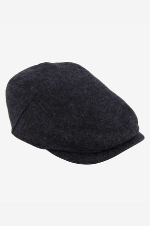 The Swanndri Bristol Flat Cap, made from a dark gray wool blend, rests on a white background. Its textured fabric and slightly curved brim make it perfect for outdoor adventures.