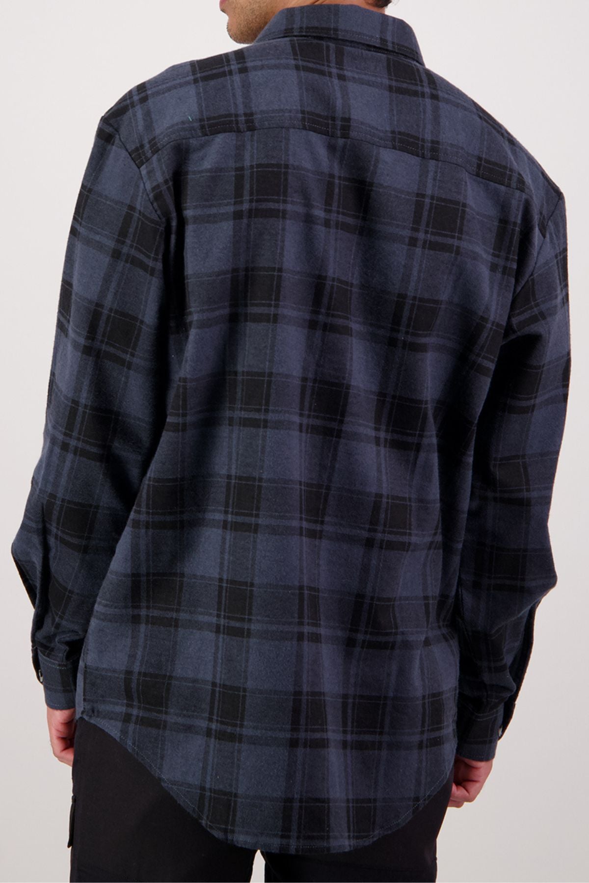 A person is shown from the back wearing a relaxed-fit Swanndri Egmont Flannelette Twin Pack shirt, featuring long sleeves and a dark blue and black plaid pattern in soft brushed cotton. Their arms are at their sides.
