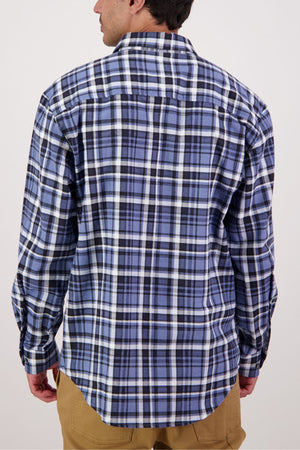 A person is seen from the back wearing the Swanndri Egmont Flannelette Twin Pack shirt in blue, black, and white plaid with tan pants against a plain background.