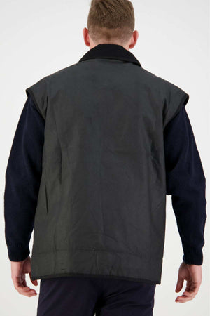 Seen from behind, a person with short hair wears the Swanndri Foxton Vest Wool Lined over a long-sleeve shirt. Their arms rest relaxed by their sides against a plain, light background.