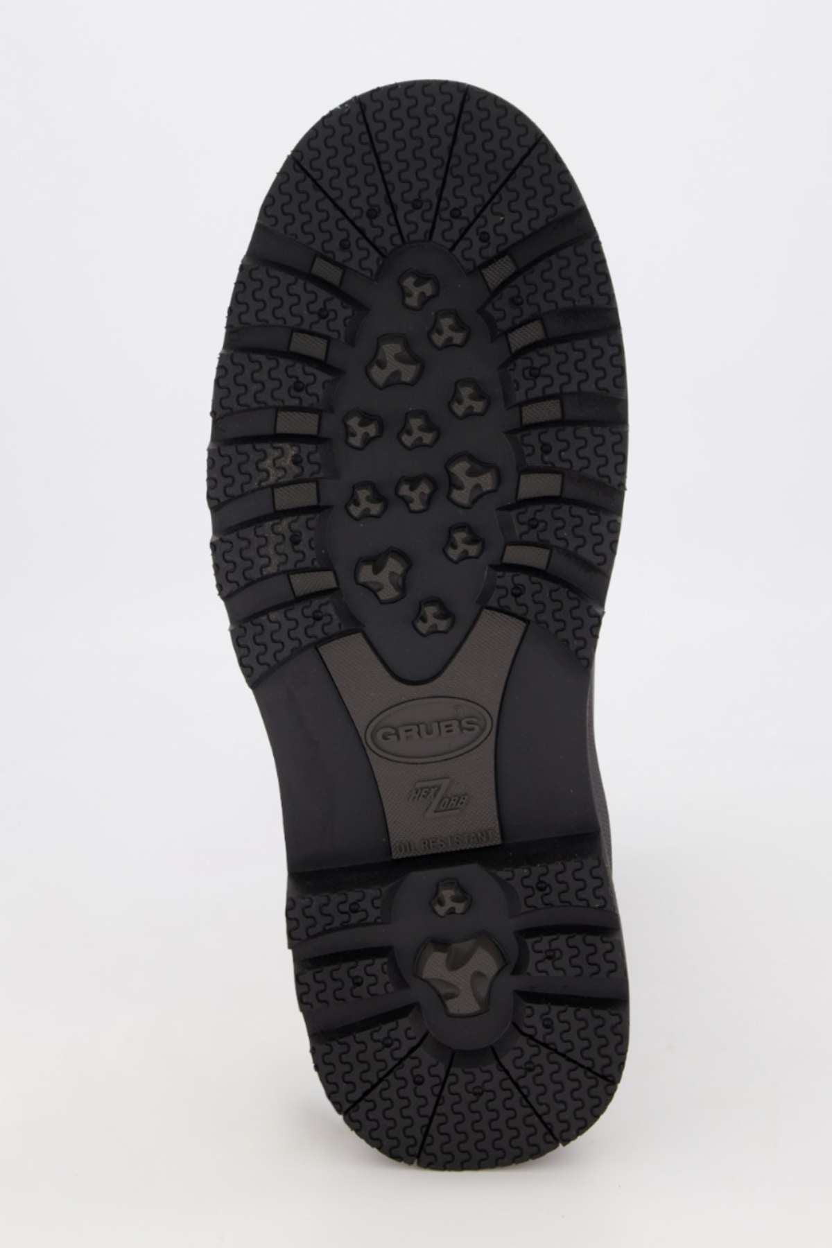 The image features the underside of a Grubs Fenline Mid Work Boot sole, showcasing black rubber with diverse tread patterns, including hexagonal shapes and large geometric designs for superior grip. The brand "Artex" and model number are embossed for maximum safety.