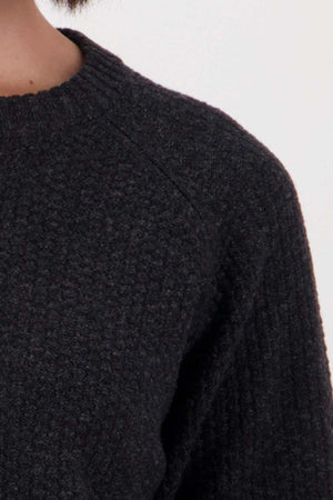 Close-up of a person wearing the Swanndri Hayes Park Waffle Knit Crew, showing shoulder, upper chest, and part of the neck against a plain light background.