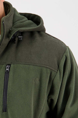 Close-up image of a person wearing the Swanndri High Rock Fleece Pullover. The green fleece jacket includes a hood and showcases a dark green shoulder panel with waterproof fabric and a zippered chest pocket. This partial view emphasizes the texture and details of the fleece lining.