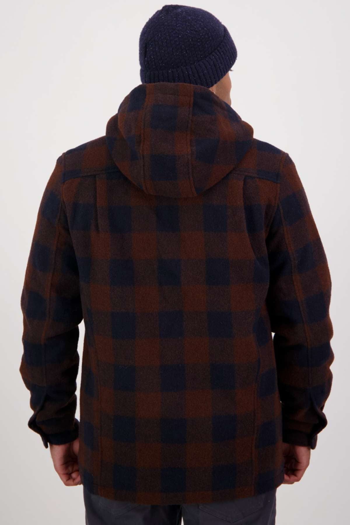 A person wearing a navy blue beanie and the Swanndri Hudson Hoodie—a brown and navy plaid, warm hard-wearing jacket—stands facing away from the camera against a plain white background.