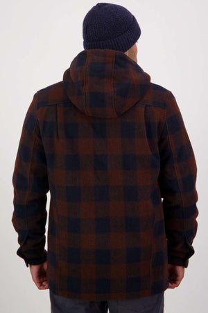 A person wearing a navy blue beanie and the Swanndri Hudson Hoodie—a brown and navy plaid, warm hard-wearing jacket—stands facing away from the camera against a plain white background.