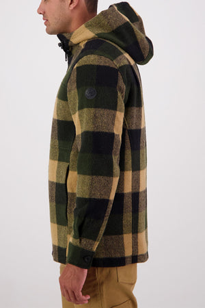 A person in profile, facing left, wears the Swanndri Hudson Hoodie in green, black, and tan plaid with khaki pants against a plain light background. Made from New Zealand wool, this jacket ensures a warm, comfortable fit.