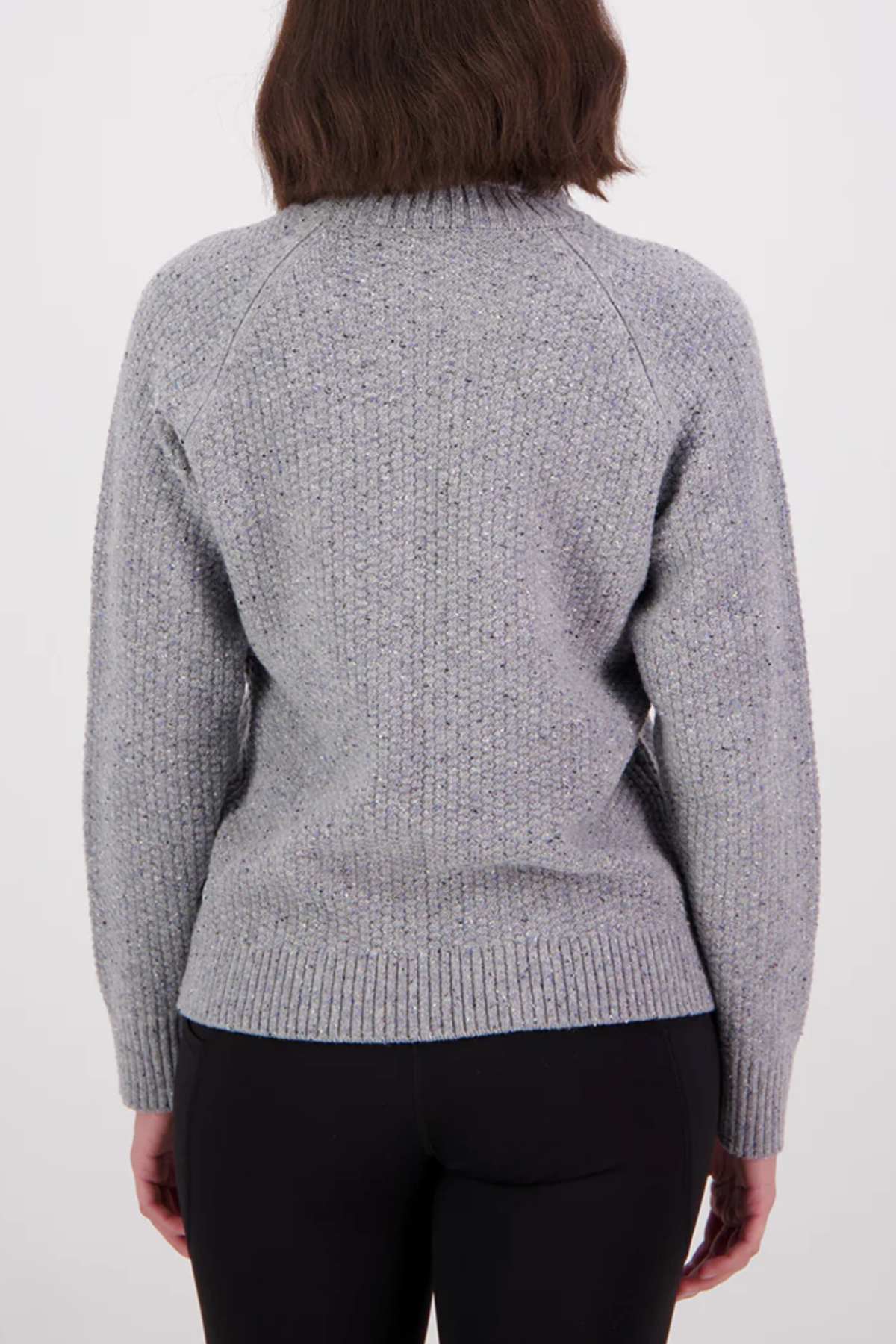 A person with shoulder-length brown hair is seen from behind, wearing the Swanndri Lyttelton v2 Roll Neck Knit in light gray with long sleeves and black pants, set against a plain white background.