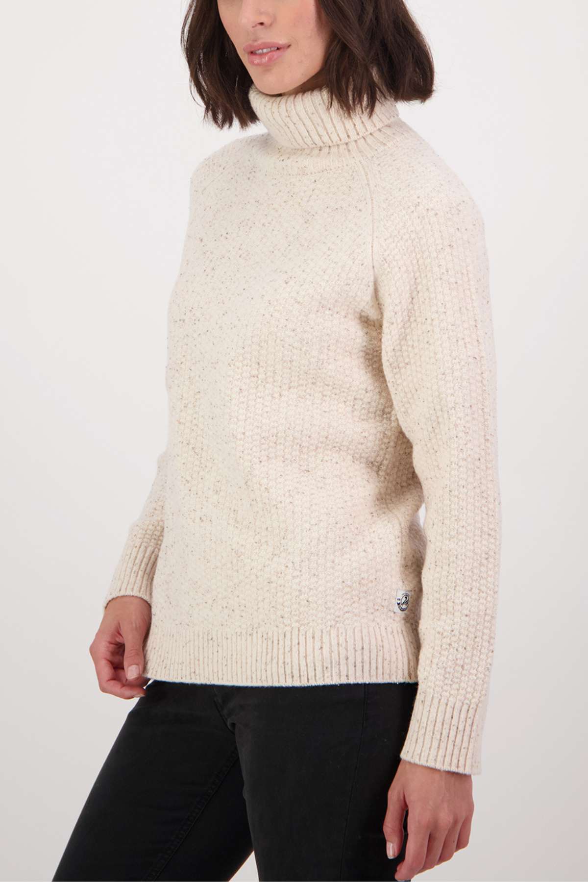 A stylish look with a Swanndri Lyttelton v2 Roll Neck Knit in cream, speckled design, paired with sleek black pants.