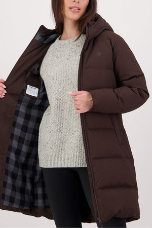 A woman wearing the Swanndri Nimbus Longline Down Coat in brown over a light gray knit sweater opens it to reveal its black and gray plaid lining, standing against a plain light background.