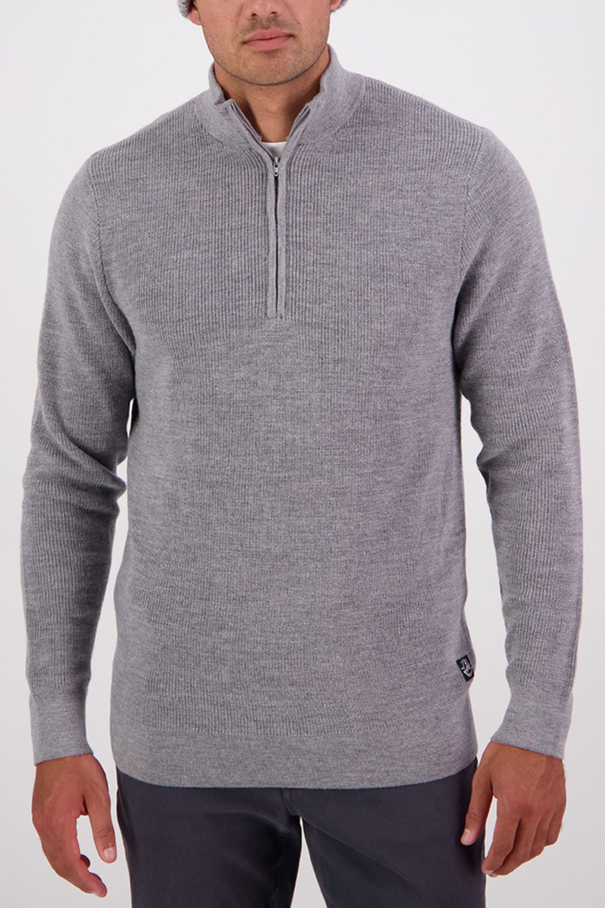 A man wearing a Swanndri Otahu River Quarter Zip Merino Knit in light grey and dark pants stands against a plain white background.
