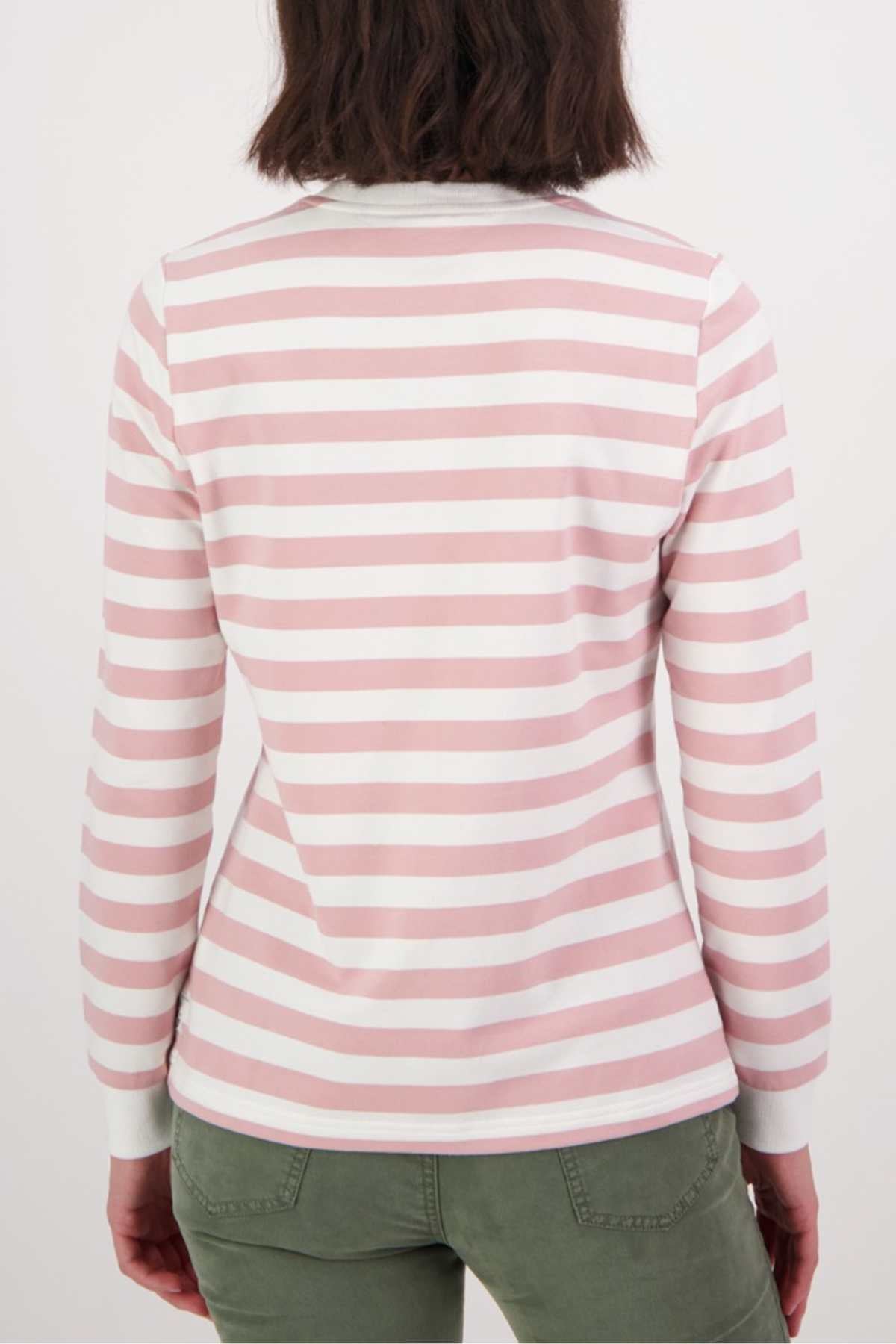 A person with shoulder-length brown hair is shown from the back, wearing a relaxed fit Swanndri Papamoa Stripe Long Sleeve Tee in pink and white stripes with olive green pants—ideal for effortless everyday wear.