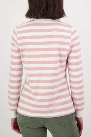 A person with shoulder-length brown hair is shown from the back, wearing a relaxed fit Swanndri Papamoa Stripe Long Sleeve Tee in pink and white stripes with olive green pants—ideal for effortless everyday wear.