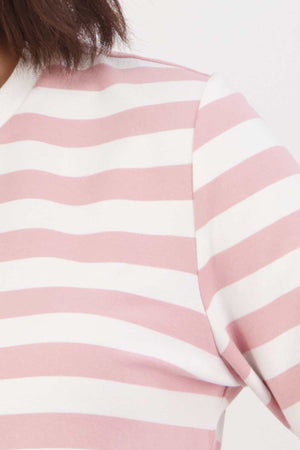 Close-up of someone wearing the Swanndri Papamoa Stripe Long Sleeve Tee in pink and white stripes. This relaxed fit top covers the shoulder and upper chest, ideal for everyday outfits, set against a plain background.
