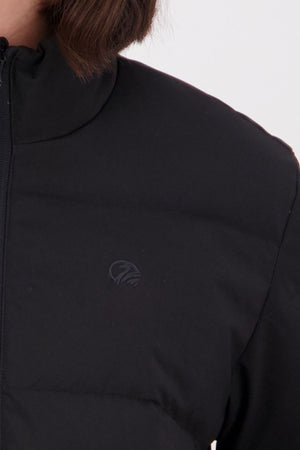 Close-up of a person wearing the Swanndri Plume Down Jacket, showing its full zip front and subtle chest logo. The durable polyester 100D Oxford fabric is visible, with brown hair against a plain light background.