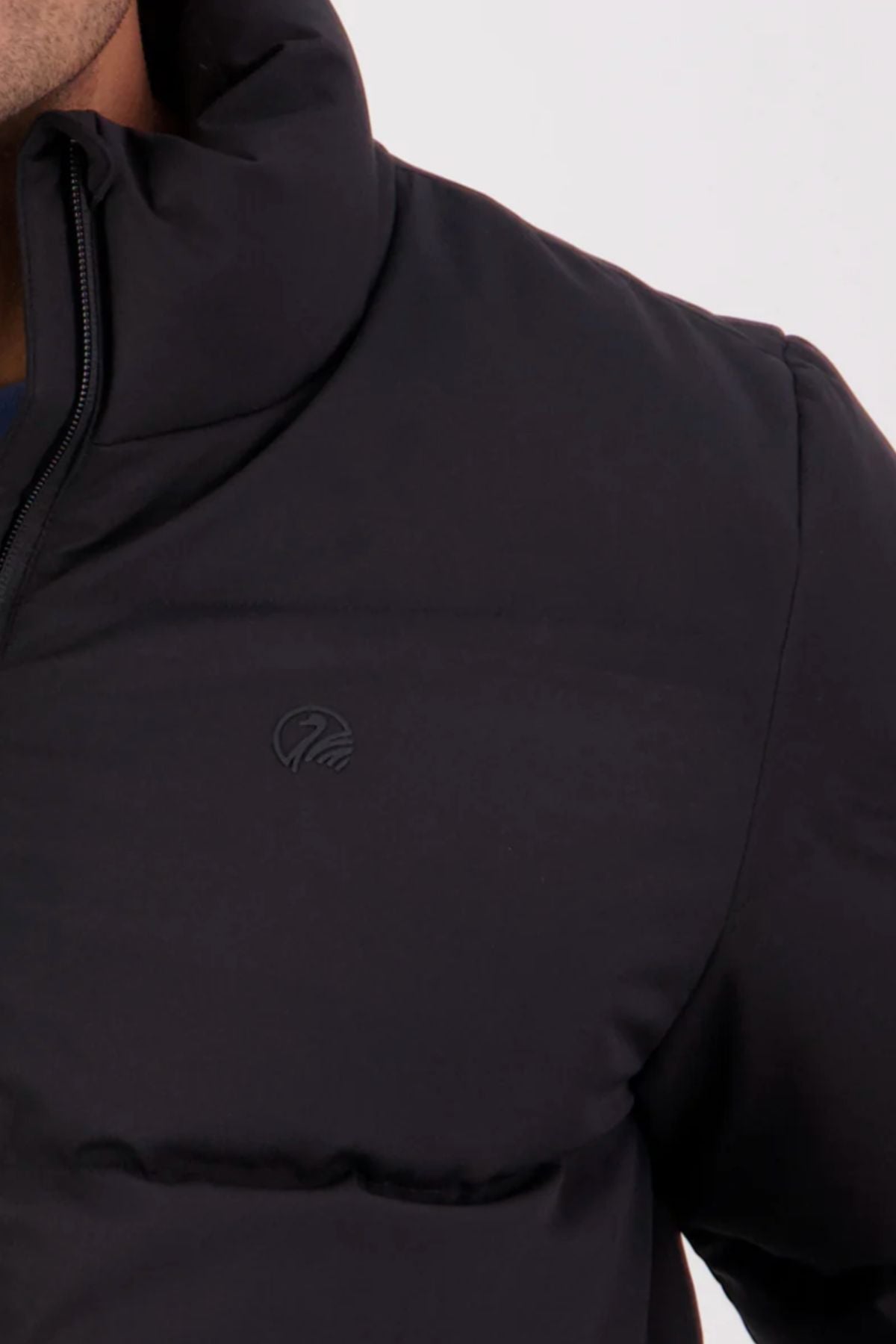A close-up of the Swanndri Plume Mens Down Jacket, featuring a high collar and subtle chest logo, filled with Duck Down. Shown from the shoulders down against a plain light background—ideal for outdoor activities.