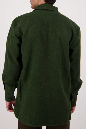 A person is shown from behind wearing a long-sleeved, dark green Swanndri Ranger Bush Shirt. Only their upper body is visible against a plain, light background.