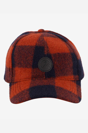 The Swanndri Swanni Wool Check Baseball Cap features a red and black plaid design, a round black front patch, adjustable fit, and is shown against a plain white background.