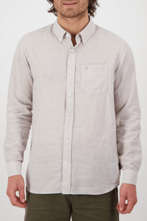 Wearing a tailored-fit Swanndri Wolcott v2 Long Sleeve Shirt with a classic collar and buttoned cuffs, crafted from a linen-cotton blend, a person pairs it with olive green pants against a plain white background.