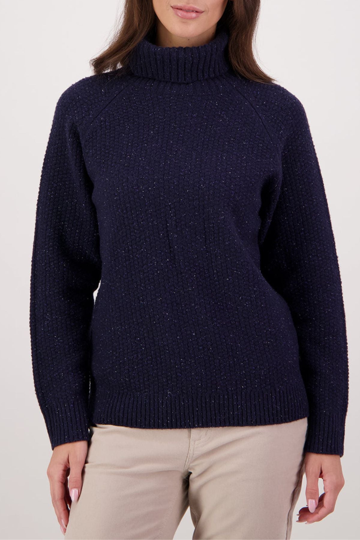 A person wearing the Swanndri Lyttelton v2 Roll Neck Knit in dark blue and light beige pants stands against a plain background. The image is cropped from shoulders to hips.