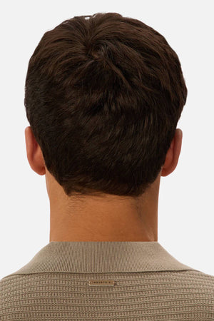 A man with short, dark brown hair is seen from behind wearing the Industrie The Alicante Polo in beige against a plain light background.
