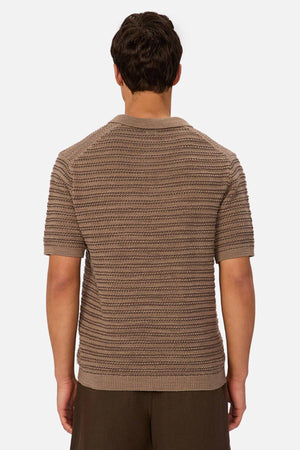 A man is seen from behind wearing the Industrie The Matera Polo in a textured brown knit paired with dark brown pants, set against a plain white background.