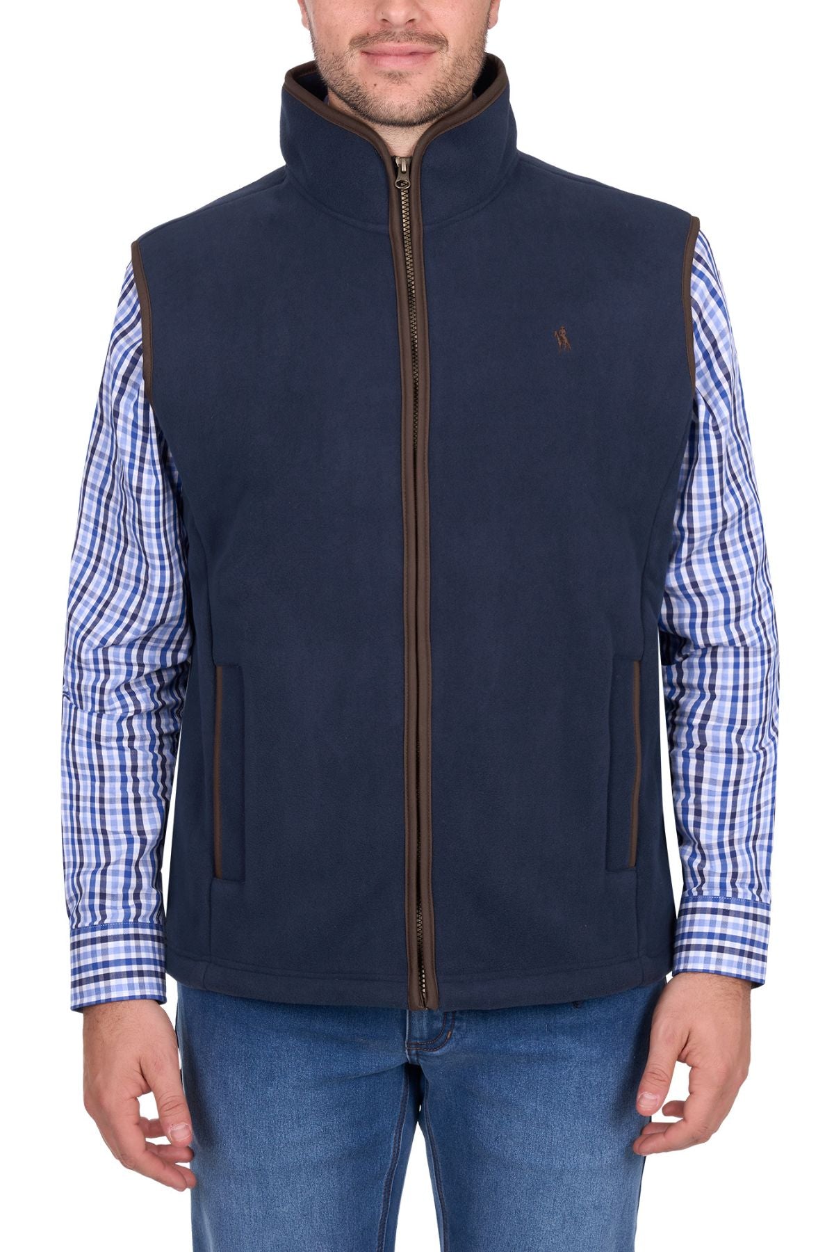 A man wearing the Thomas Cook Adrian Vest in navy blue over a blue and white checkered shirt with blue jeans, standing against a white background.