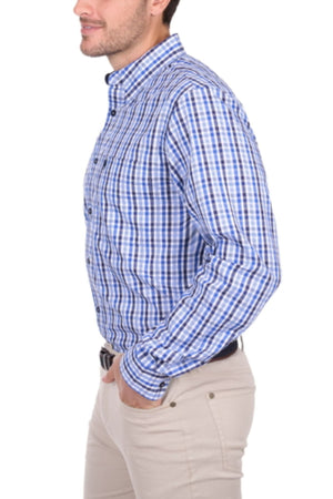 Wearing the Thomas Cook Andrew Shirt—blue and white checkered, cotton, long sleeve—a man stands in profile with one hand in his pocket and beige pants against a white background.