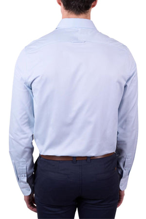 A man is seen from behind wearing the Thomas Cook Callum Tailored Shirt in light blue, made from premium woven fabric, tucked into dark blue pants with a brown belt. The plain white background highlights the look.