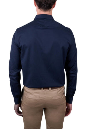 A man is seen from behind wearing a dark navy Thomas Cook Callum Tailored Shirt and light tan pants, with his arms relaxed at his sides against a plain white background.