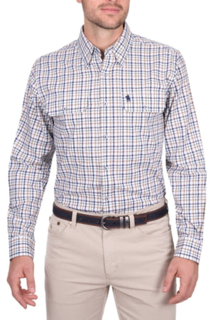A man wears the Thomas Cook Chad Shirt, a long-sleeve, button-up plaid cotton shirt in white, blue, and tan with a small chest logo, paired with light beige pants and a dark brown belt.