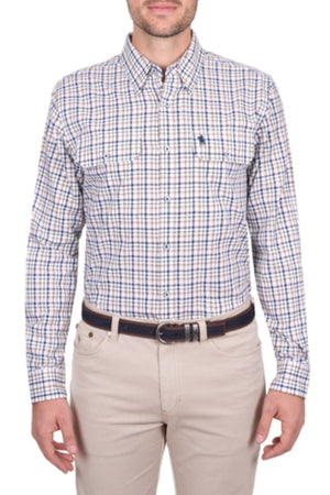 A man wears a Thomas Cook Chad Shirt—long sleeve, button-up, blue and white plaid cotton—tucked into beige pants with a dark belt, standing against a plain background.