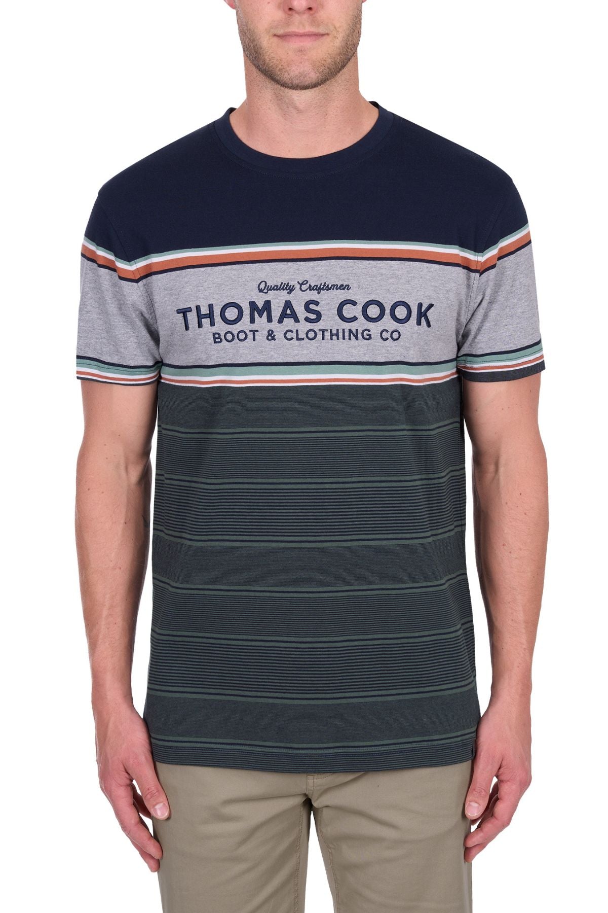 A man wearing the Thomas Cook Dion Tee, a multi-colour striped 100% cotton jersey with "Thomas Cook Boot & Clothing Co" on the front, paired with beige pants and standing against a white background.