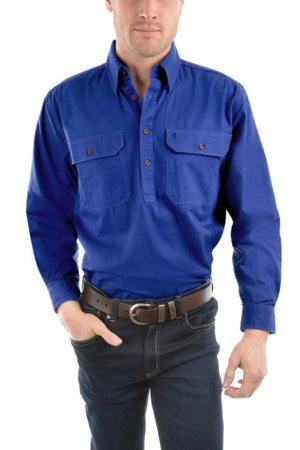 A person wearing a bright blue Thomas Cook Heavy Drill Half Placket Shirt with two front pockets, paired with dark jeans and a black belt, stands against a plain white background.
