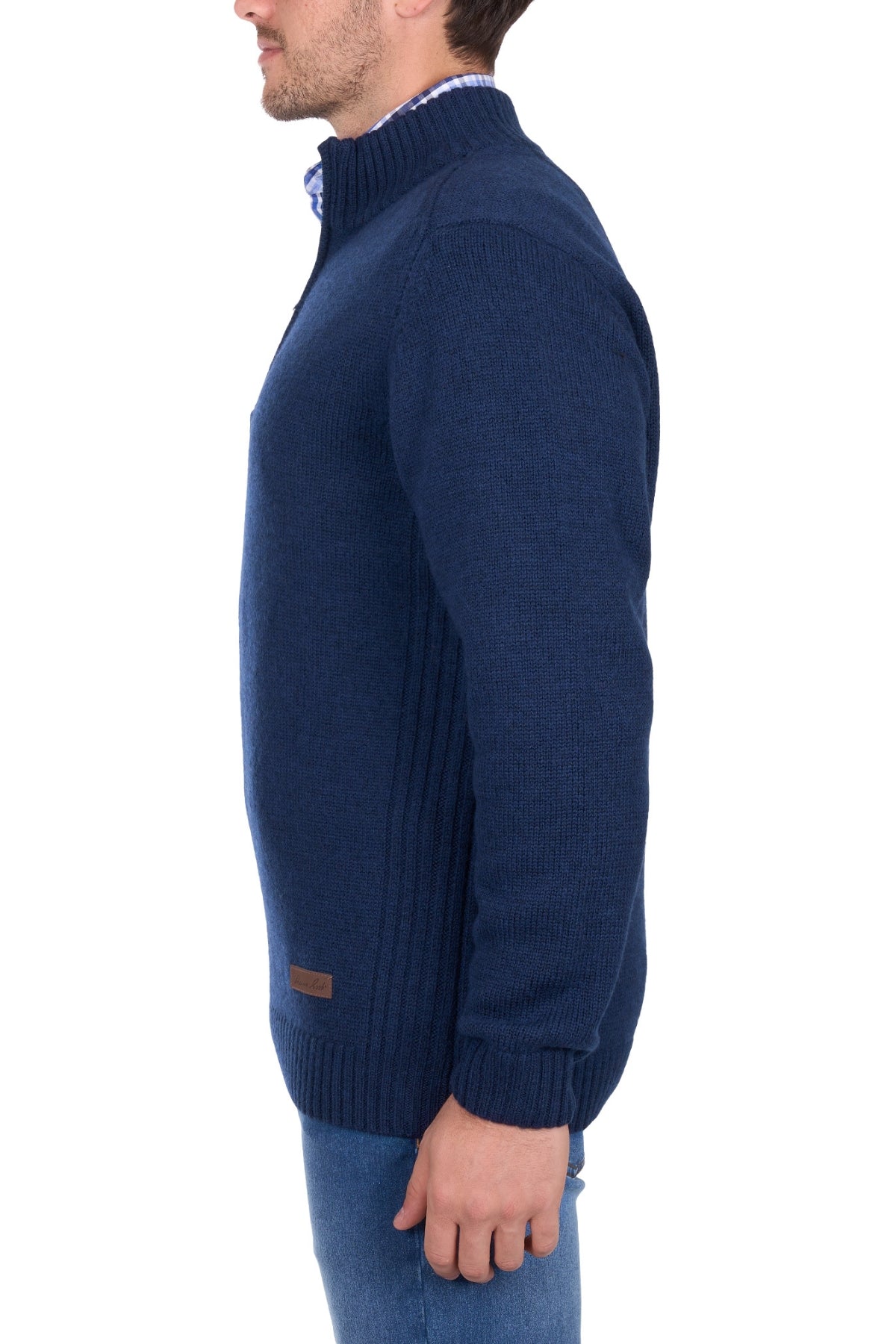 A man in a Thomas Cook Jesse 1/4 Zip Jumper and blue jeans stands in profile against a white background.