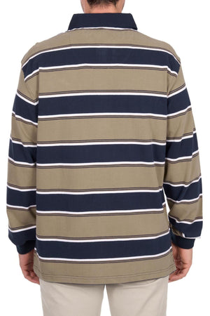 A person is seen from behind wearing the Thomas Cook Jose Rugby shirt, featuring horizontal navy, white, and olive green stripes with a dark collar and heavyweight jersey fabric, paired with light-colored pants.