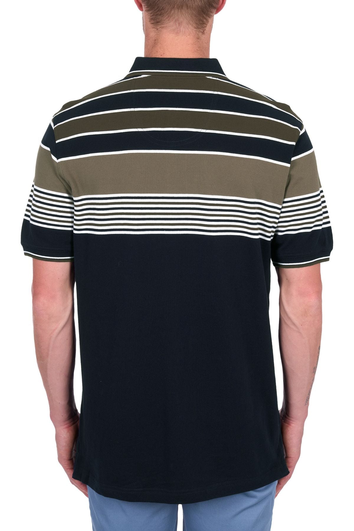 A man faces away, wearing the Thomas Cook Josua Polo—100% cotton pique with horizontal white, olive, and navy stripes—paired with light blue pants, set against a white background.