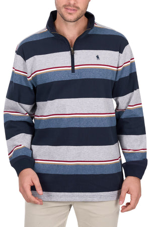 A man wearing the Thomas Cook Nathan 1/4 Zip Rugby, a navy and gray striped long-sleeve pullover with a quarter-zip collar and small embroidered logo on the left chest, paired with light-colored pants.