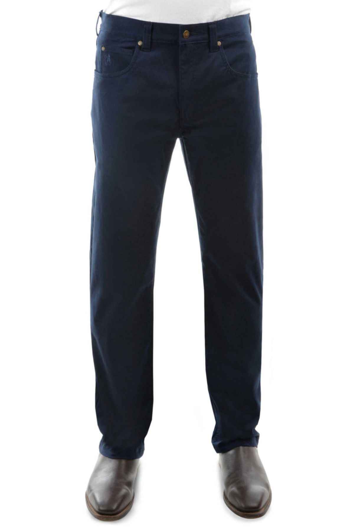 A person models the Thomas Cook Tailored Moleskin Jean in dark blue with a white shirt tucked in and brown dress shoes, standing against a white background. The image is cropped from the waist down.