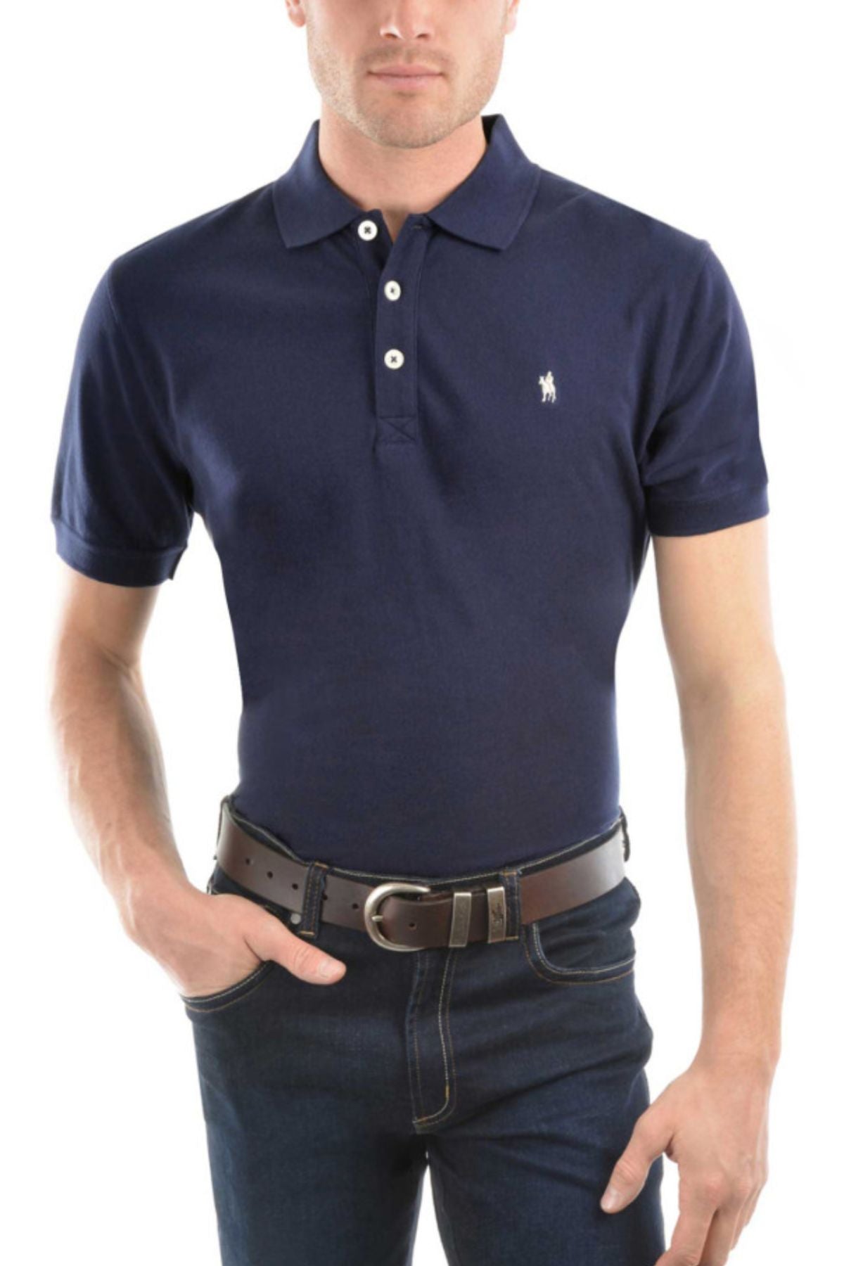 A man stands against a white background, wearing the Thomas Cook Tailored Polo in navy blue 100% cotton pique, paired with dark jeans and a dark brown belt, one hand in his pocket.
